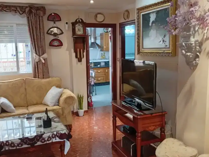 Sala d'estar de Casa adosada en venda en Motril amb Aire condicionat, Jardí privat i Moblat