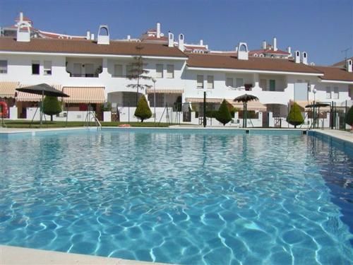 Vista exterior de Casa adosada en venda en El Portil amb Terrassa, Traster i Piscina comunitària
