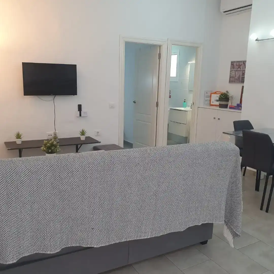 Sala d'estar de Pis de lloguer en Conil de la Frontera amb Aire condicionat, Jardí privat i Piscina